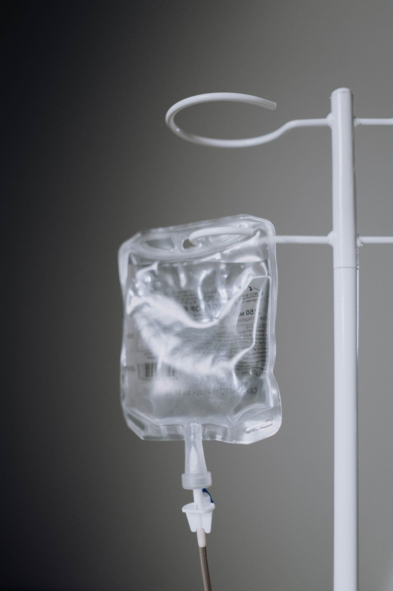 Bolsa de soro pendurada no suporte branco, pronta para a sessão de soroterapia